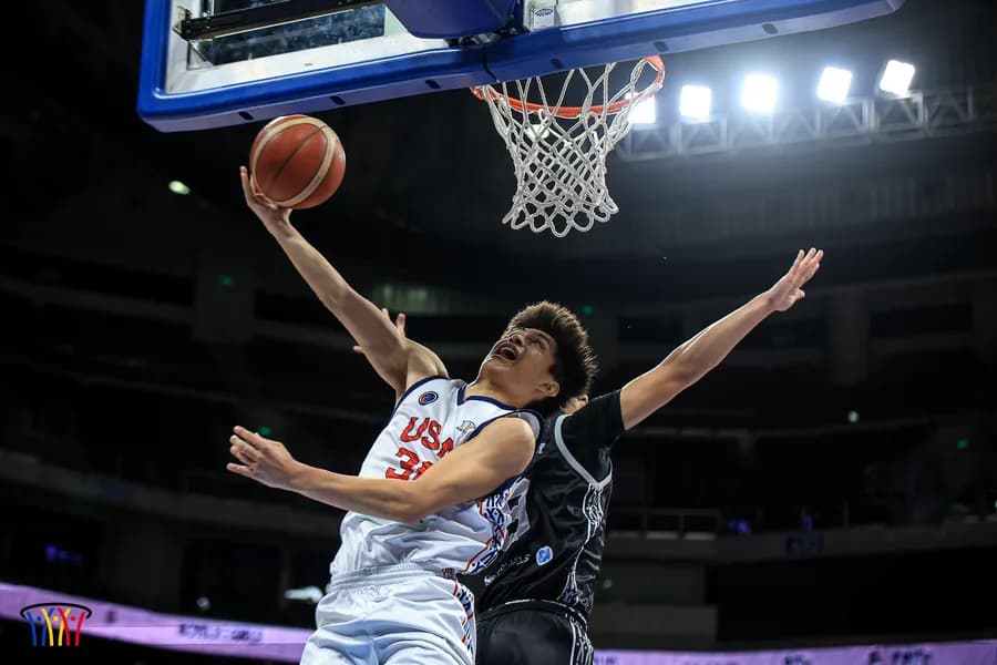 A guard drives to the basket under the arena lights